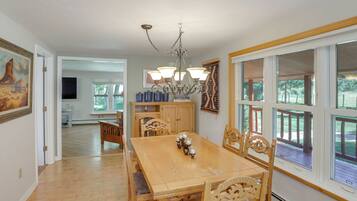 A dining area with a wooden table, chairs, and a chandelier.
