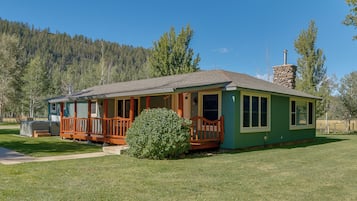 A single-story house with a porch, a chimney, and a small front yard.