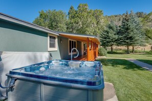 A hot tub outside a house with a covered porch and a lawn. - Dolores Ranch Cabin w/ Hot Tub & 1-acre Yard! (Dolores)