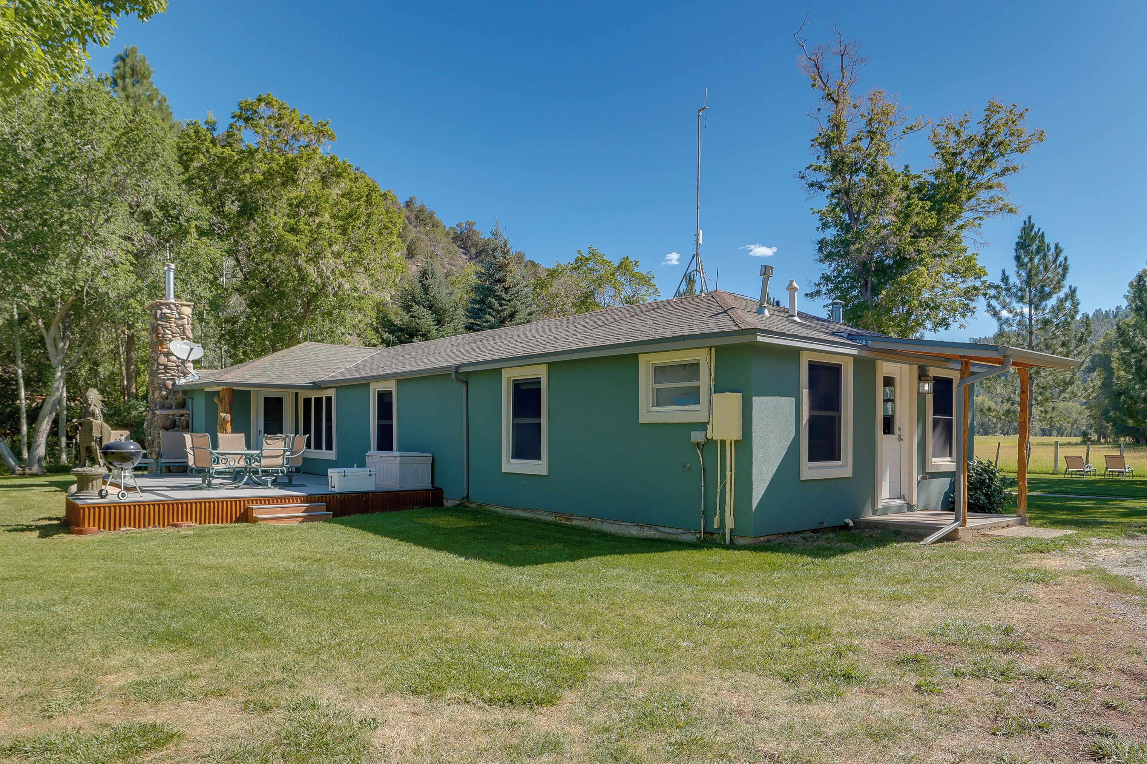 A small house with a covered porch, a barbecue grill, and a satellite dish.
