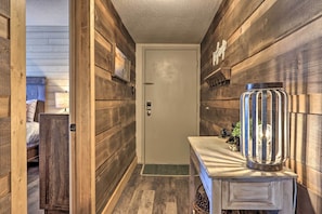 A narrow hallway with wooden walls and a door. There is a small table with a decorative lamp and a plant on it. - 4 Mi to Natl Park: Mtn-view Gatlinburg Retreat! (Gatlinburg)