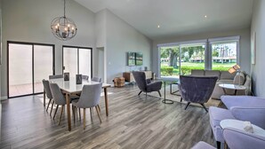 Un salón amplio con una mesa de comedor, sillas modernas y una araña.
