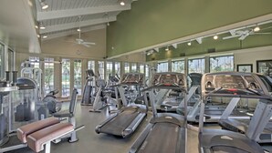 Un gimnasio con cintas de correr, máquinas elípticas y equipo de pesas.