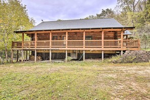 A wooden cabin with a balcony, a stone foundation, and a grassy yard. - Splendid Family Cabin w/ Hot Tub & Grill! (Lake City)