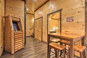A wooden interior with a wooden table and benches, a wooden cabinet, and a wooden door with a sign. - Luxe Cabin w/ Home Theater < 2 Miles to Gatlinburg (Gatlinburg)