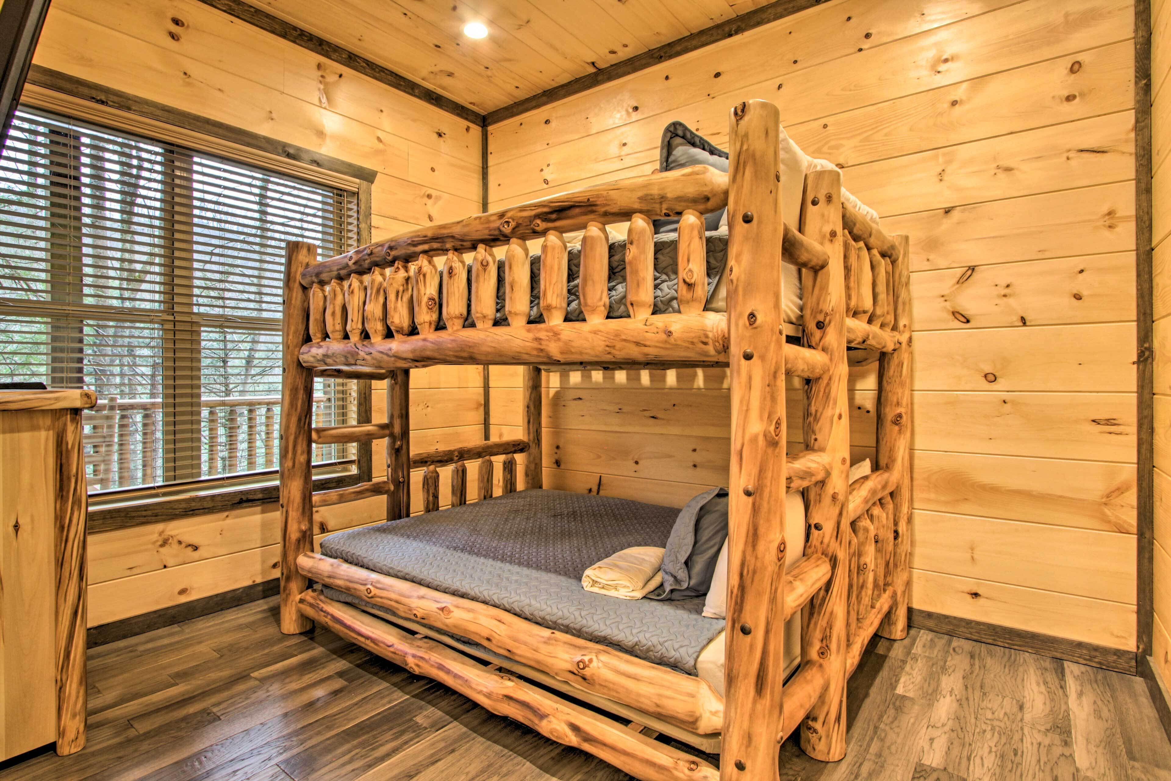 Een stapelbed met een houten frame en een matras in een kamer in chaletstijl, met houten wanden en een raam.