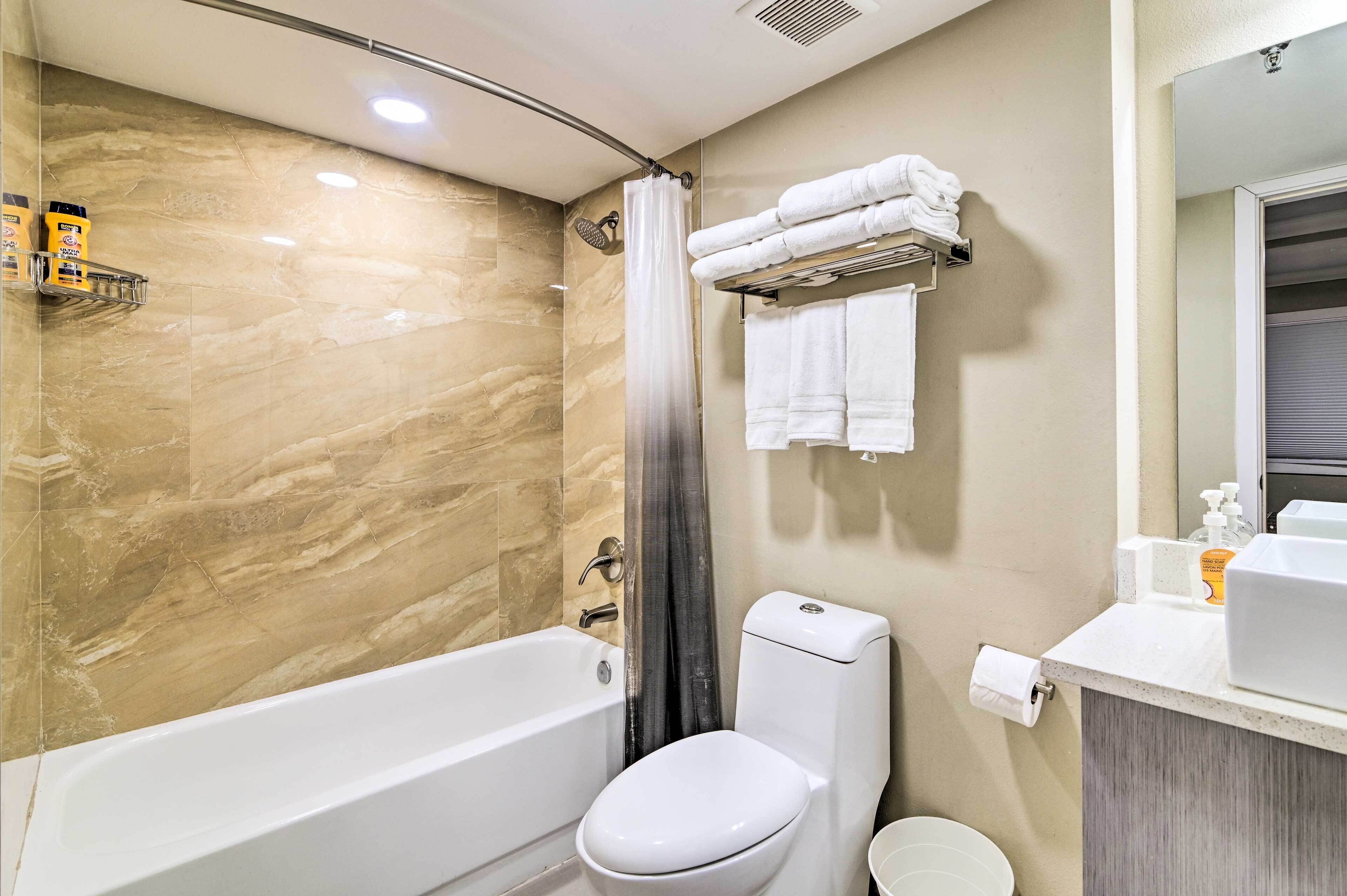 Ein modernes Badezimmer mit Badewanne, Toilette und Duschvorhang.