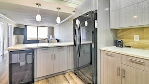 A modern kitchen with a built-in refrigerator, a dishwasher, and a coffee maker on the countertop. - Waterfront Condo: Resort Pool, Tennis & Beach (Hudson)