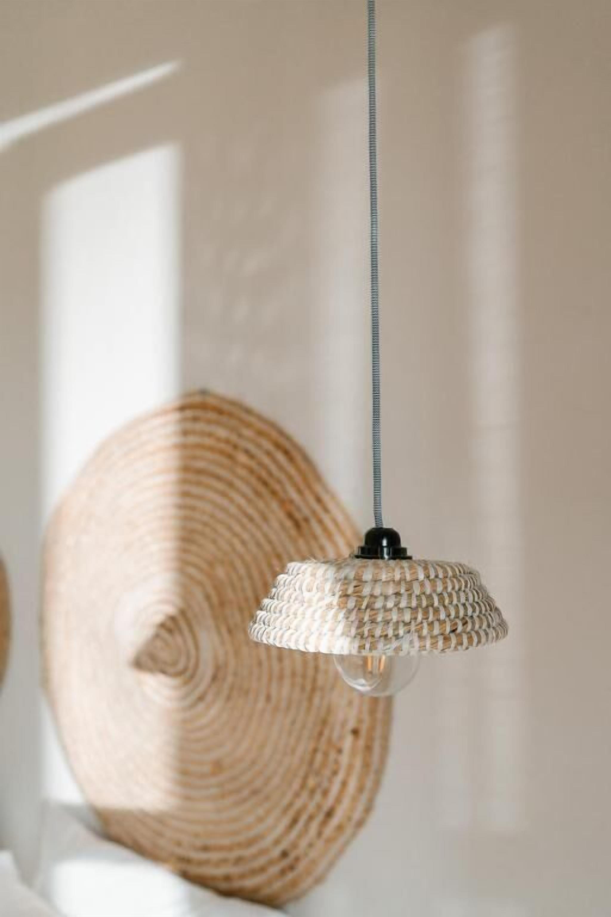 A woven pendant light fixture hanging from a ceiling.