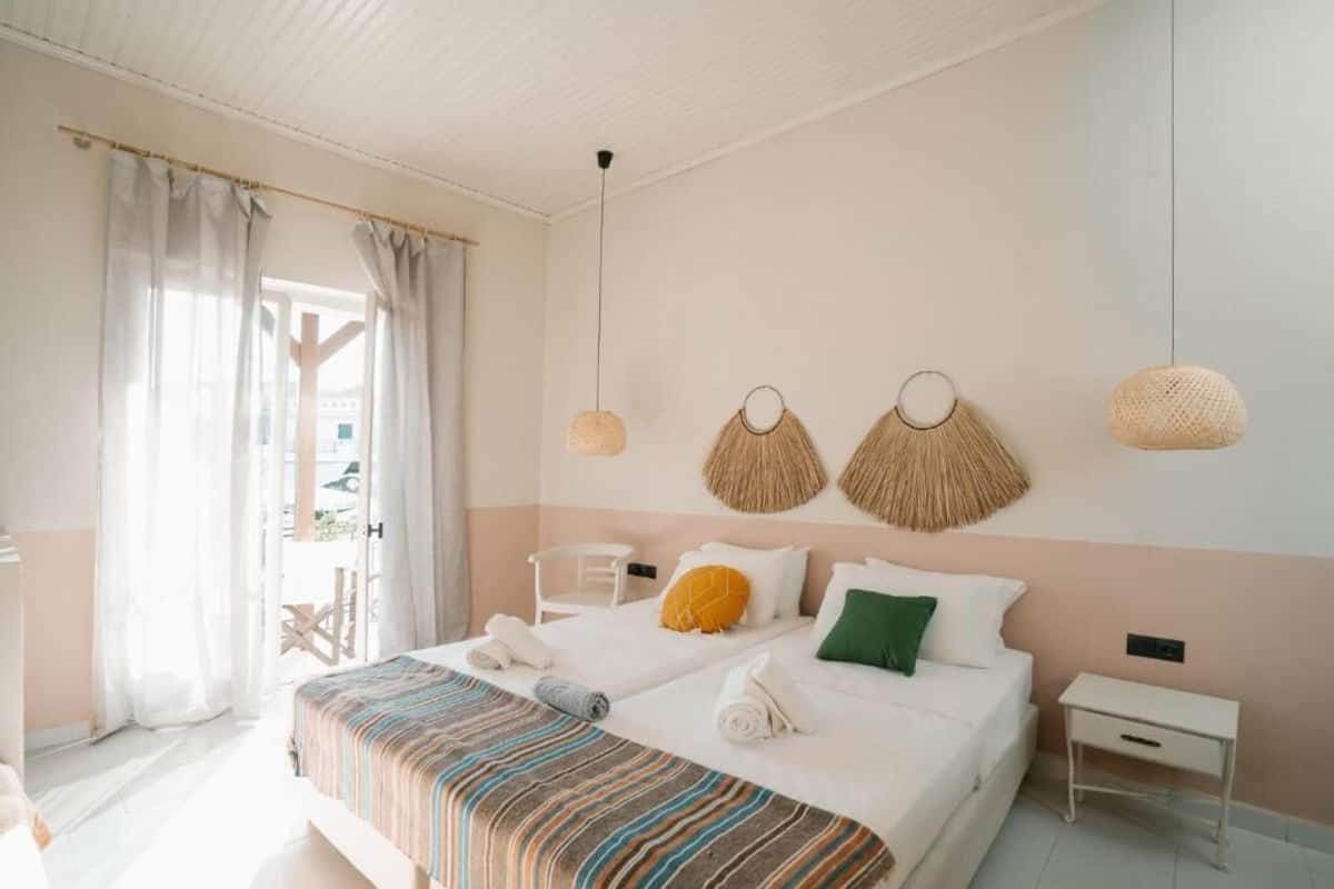A bedroom with a bed, two bedside tables, a chair, and a window with curtains.