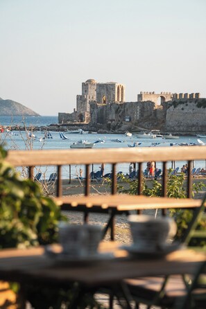 A coastal view with a historic castle and boats. - Filanthi The Project (Pylos-Nestoras)