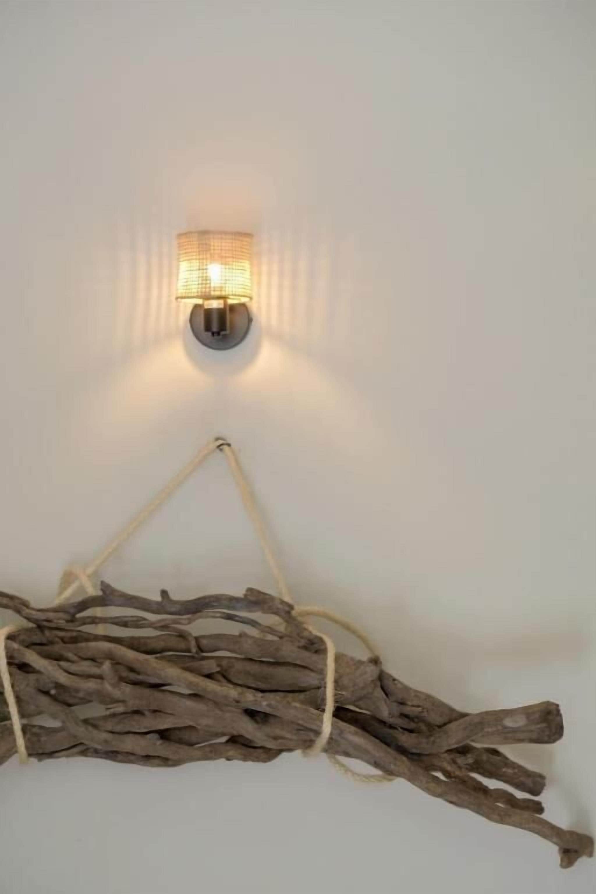 A wall-mounted light fixture with a rustic branch decoration below it.