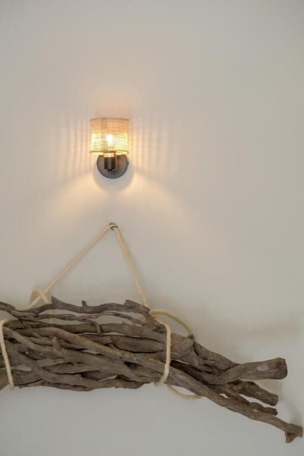 A wall-mounted light fixture with a rustic branch decoration below it.