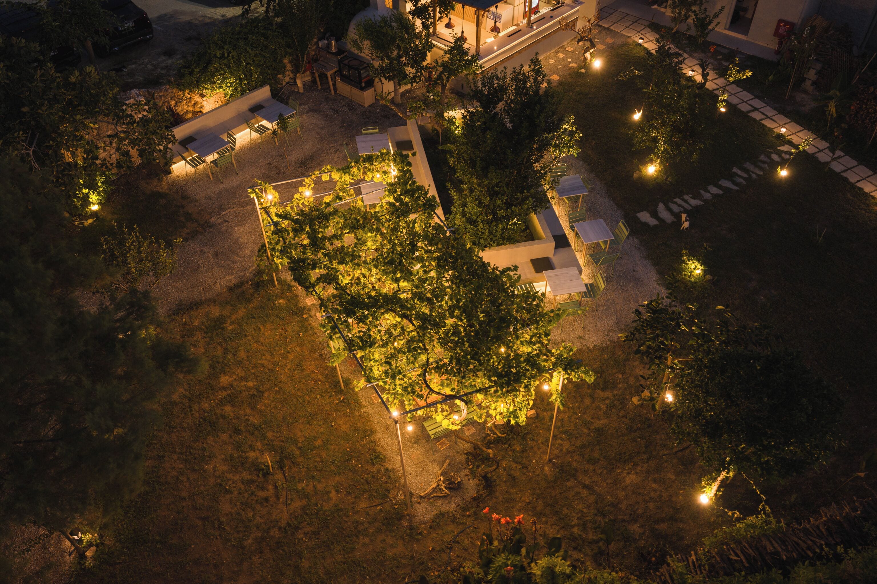 An aerial view of a landscaped garden area with pathways, seating, and a central garden bed.