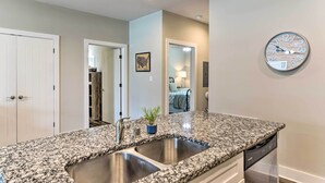 A kitchen with granite countertops, stainless steel sinks, and a dishwasher. - Bowling Green Apartment in the Heart of Town! (Bowling Green)