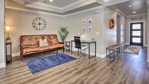 Un salon moderne avec un canapé en cuir, un bureau et une grande horloge murale.