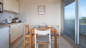 Una cocina con una mesa de comedor para dos, una ventana con vistas y una lámpara en el techo.