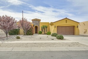 A residential house with a stone tower, a garage, and a well-maintained front yard with a tree and shrubs. - Unique Las Cruces Home w/ Patio + Gas Grill! (Las Cruces)