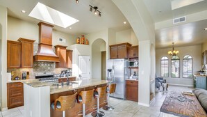A spacious kitchen with a large island, bar stools, and modern appliances. - Unique Las Cruces Home w/ Patio + Gas Grill! (Las Cruces)
