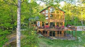 Eine Holzhütte mit einer Terrasse, umgeben von Bäumen.