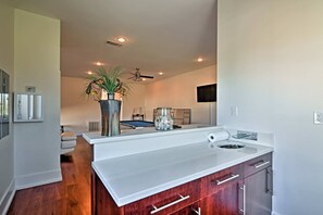 A modern kitchen with white countertops, wooden cabinets, a ceiling fan, recessed lighting, a ping pong table, and a large potted plant. - Gorgeous Ocean Springs Waterfront Home w/ Dock! (Ocean Springs)