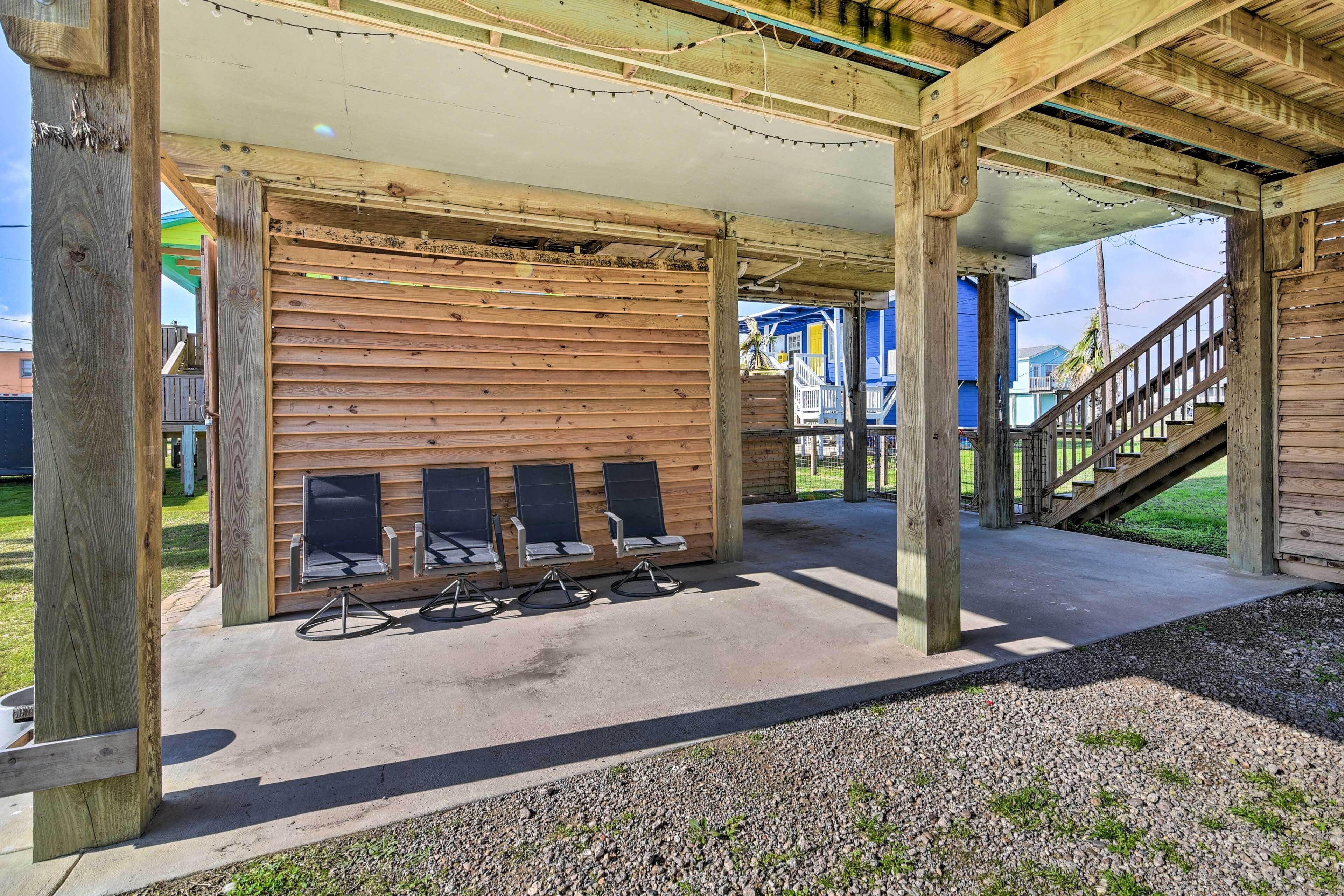 A covered outdoor seating area with wooden benches and a concrete floor.