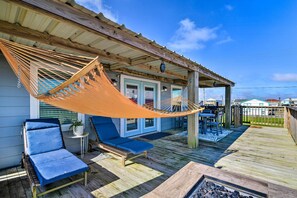 A wooden deck with a hammock, two lounge chairs, and a small table. - Steps to Sand: Surfside Beach Gem w/ Large Yard (Freeport)