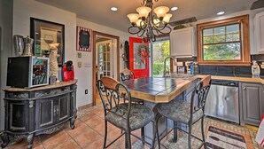 A kitchen with a dining table, chairs, a chandelier, and a coffee machine. - Unique & Historic Home Walk to Lake Champlain (Plattsburgh)