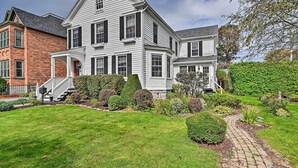 A large, two-story house with a prominent front porch and a well-maintained front yard. - Unique & Historic Home Walk to Lake Champlain (Plattsburgh)