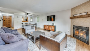 Ein Wohnzimmer mit Kamin, Sofas, einem Couchtisch und einem Essbereich mit Stühlen und Tisch.
