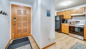 Eine Küche mit Holzausstattung, einem Edelstahlkühlschrank und einem Backofen.