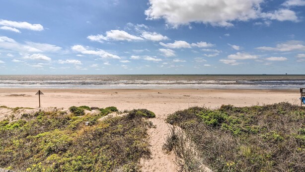 A beach with a sandy path leading to the ocean, surrounded by vegetation. - Walk to Ocean: Coastal Home in Crystal Beach! (Port Bolivar)