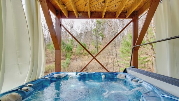 A hot tub with a wooden frame and a view of a forest. - Broadway Cabin w/ Hot Tub: Hike & Ski (Broadway)