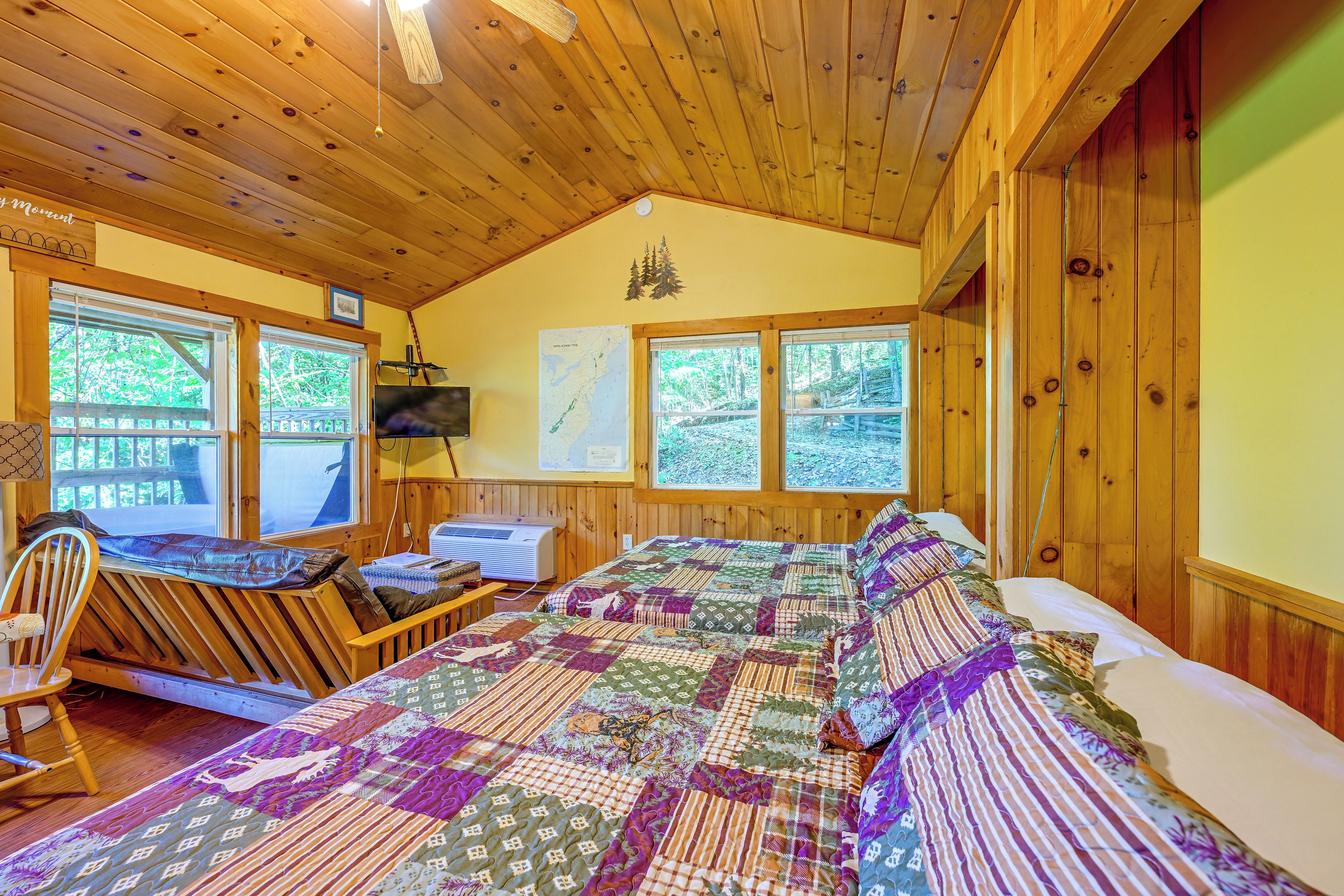 A cozy cabin room with a large bed, a desk, and a chair.