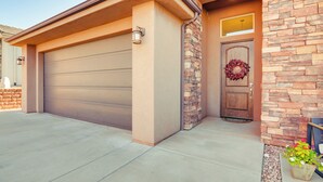 Un garage attenant à une maison, doté d’une façade en pierre et d’une porte en bois.