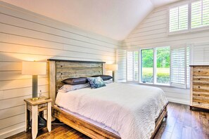 A bedroom with a wooden bed, white walls, and a window with shutters. - Elegant Sapphire Valley Studio w/ Resort Amenities (Sapphire)