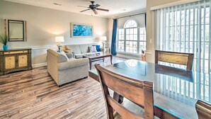 A dining area with a glass-top table, wooden chairs, and a ceiling fan. - Steps to Pool: Myrtle Beach Vacation Rental! (Myrtle Beach)