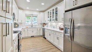 A modern kitchen with white cabinetry, stainless steel appliances, and a wooden floor. - Keowee Keys Condo w/ Resort Amenities Access! (Salem)
