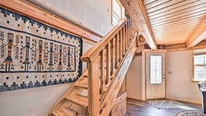 A wooden staircase with a patterned rug on the wall and a door with a glass panel. - 4-season Mountain Escape With Breathtaking View! (Coaldale)