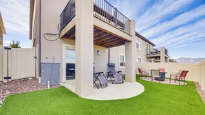 Un bâtiment à deux étages doté d’un patio couvert comprenant un espace salon extérieur et une pergola.