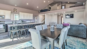 Eine geräumige Küche mit Essbereich, ein Wohnzimmer mit Sofa und eine Treppe, die in einen oberen Bereich führt.
