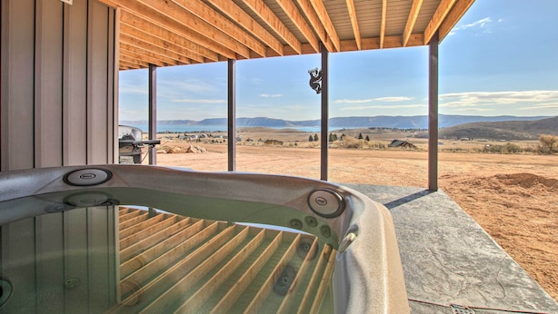 Ein Whirlpool unter einer hölzernen Pergola mit Blick auf eine Wüstenlandschaft.