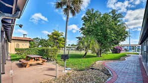 A paved walkway with a picnic table and a palm tree. - Everglades Studio W/marina View, Patio+pool Access (Naples)