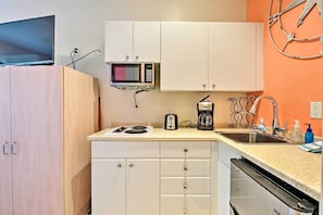 Een magnetron, een oven, een kookplaat, kookgerei, borden en bestek