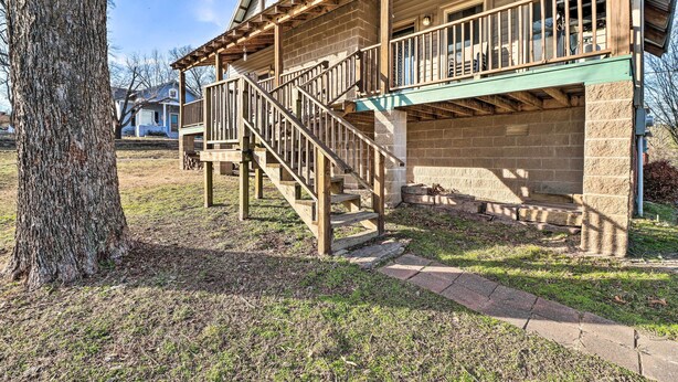 A two-story house with a wooden porch, a staircase, and a brick exterior. - Calico Rock Home, Walk to White River & Dtwn! (Calico Rock)