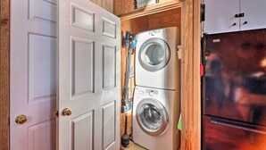 A laundry room with a white door, a washing machine, and a refrigerator. - Calico Rock Home, Walk to White River & Dtwn! (Calico Rock)