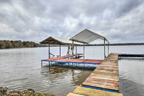 A wooden dock extending into a calm lake with a covered seating area and a shelter. - Lakefront Wisconsin Dells Home w/ Game Room (Wisconsin Dells)