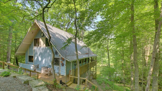 Een houten chalet met een terras, een trap en een veranda.