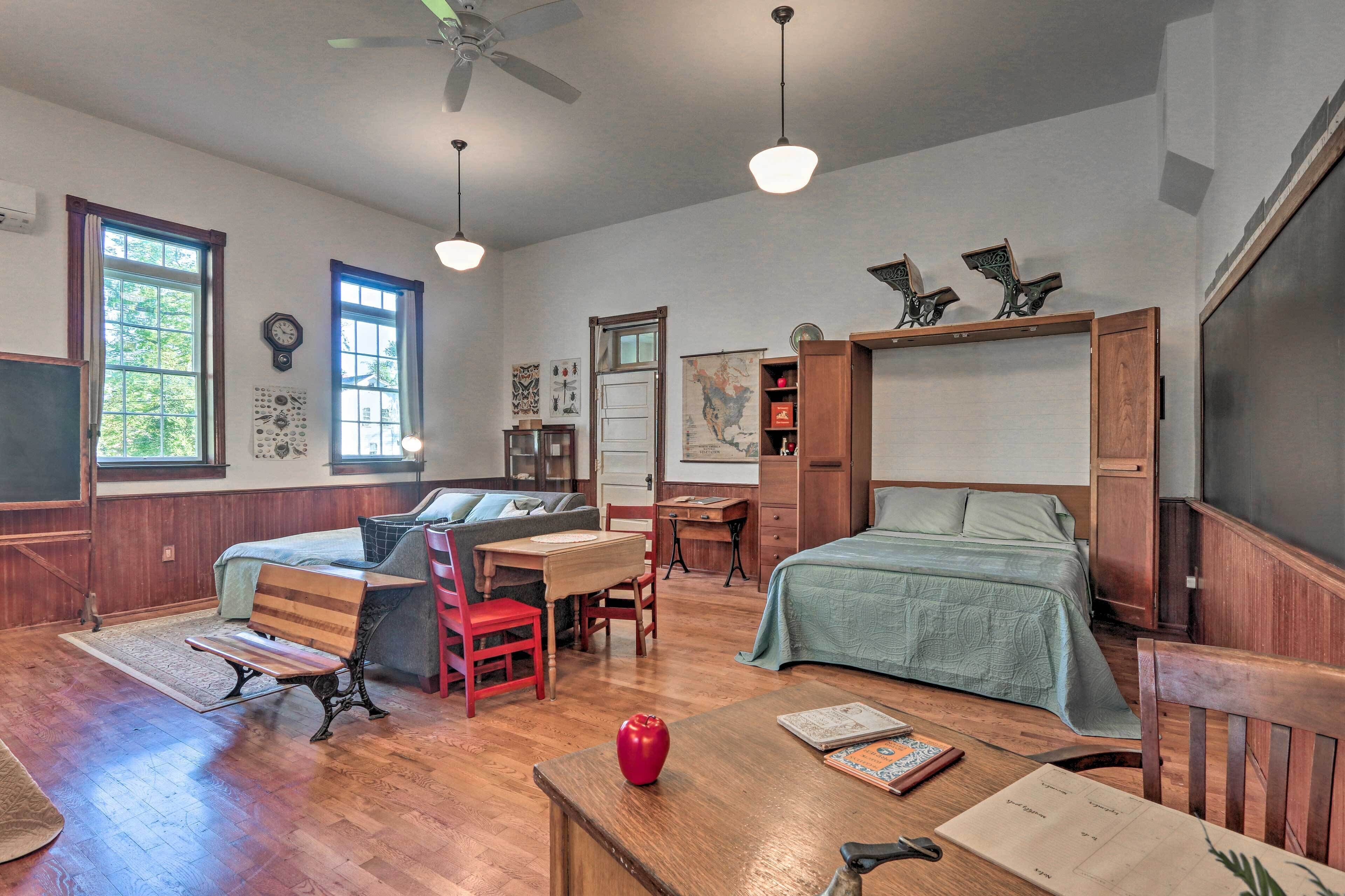A cozy room with a bed, a desk, a chair, and a bookshelf.