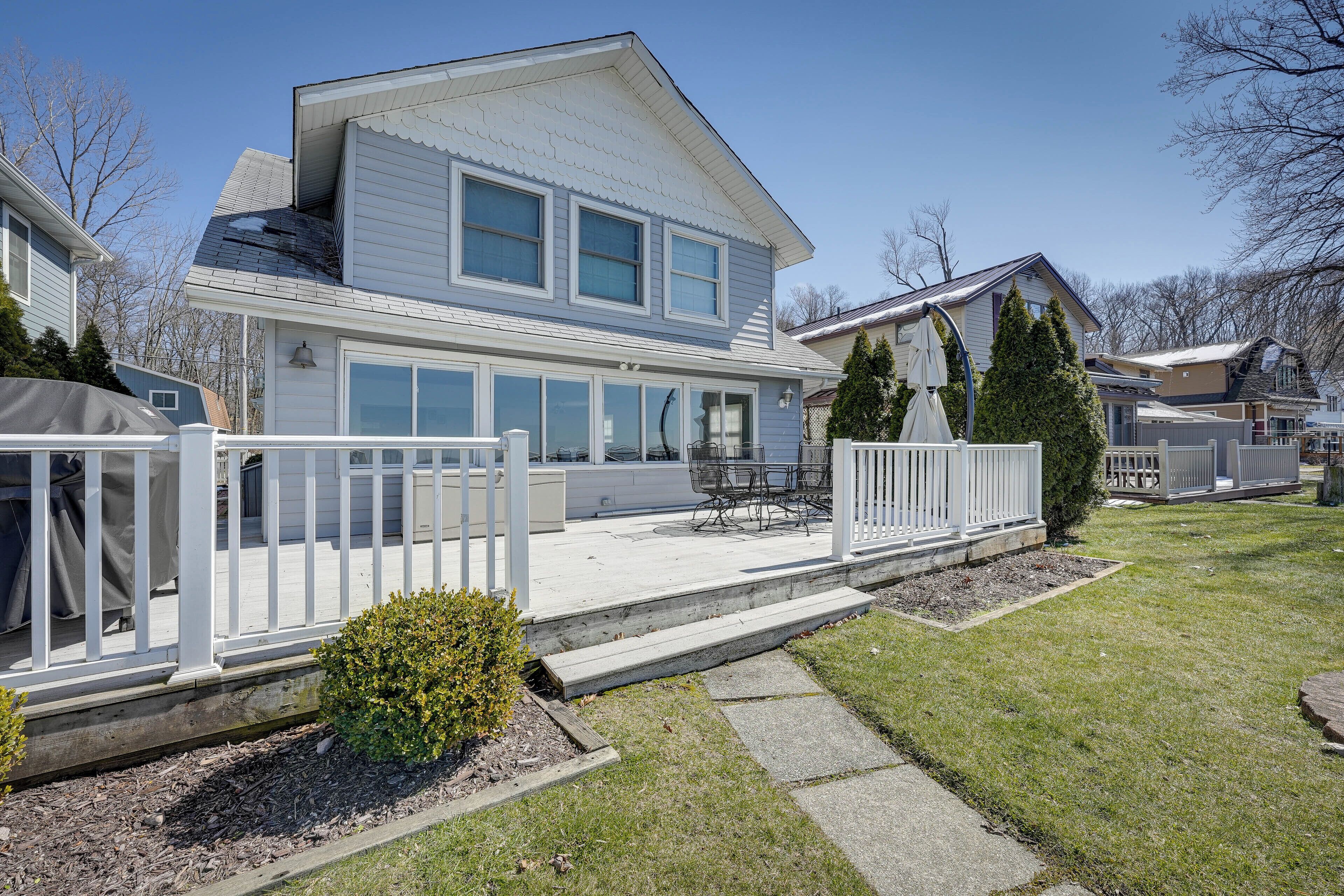 A two-story house with a covered patio and a fenced deck area.